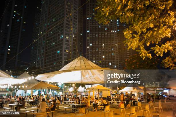 People sit under canopies at Greenfield District Central Park, developed by Greenfield Development Corp., in the Mandaluyong City in Metro Manila,...