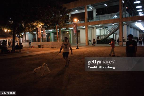 Man walks a dog at Greenfield District Central Park, developed by Greenfield Development Corp., in the Mandaluyong City in Metro Manila, Philippines,...