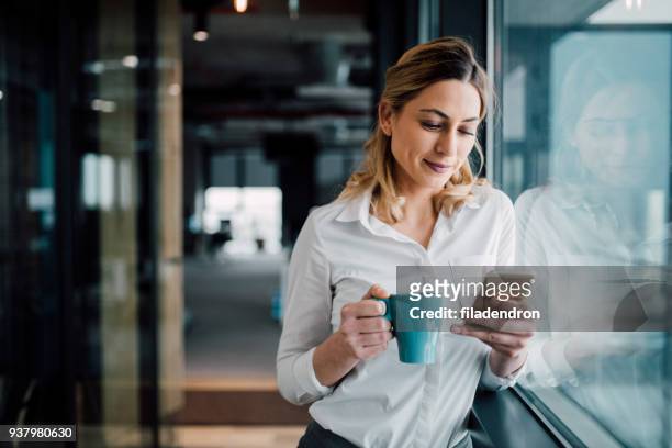 professional businesswoman texting - pausa para café imagens e fotografias de stock