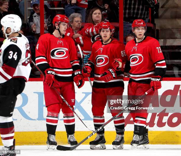 Teuvo Teravainen of the Carolina Hurricanes scores a goal and celebrates with teammates Haydn Fleury and Valentin Zykov during an NHL game against...