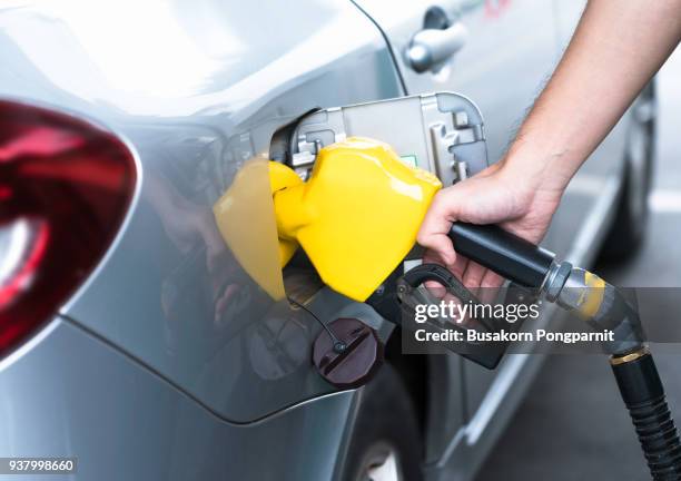 hand refilling the car with fuel, close-up. - essence photos et images de collection