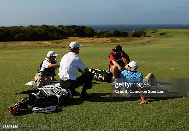 John Senden of Australia and caddies sit on the 13th fairway as play is suspended due to prevailing winds during the second round of the 2009...