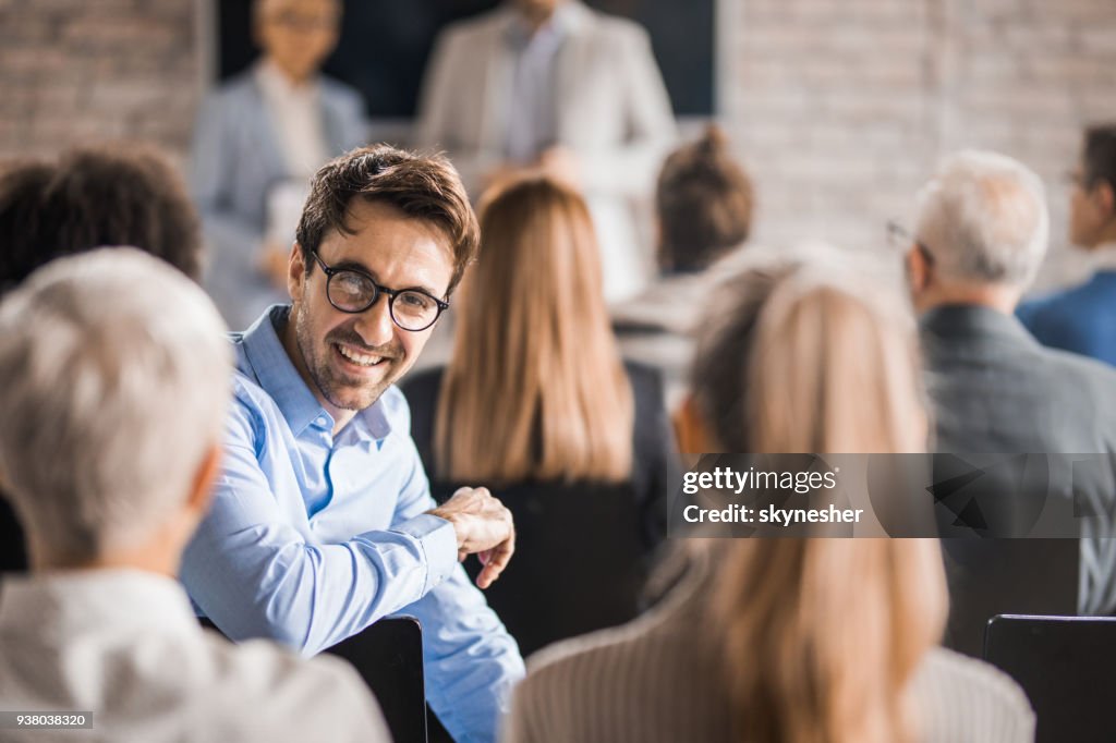 Young happy businessman attending a training class in a board room.