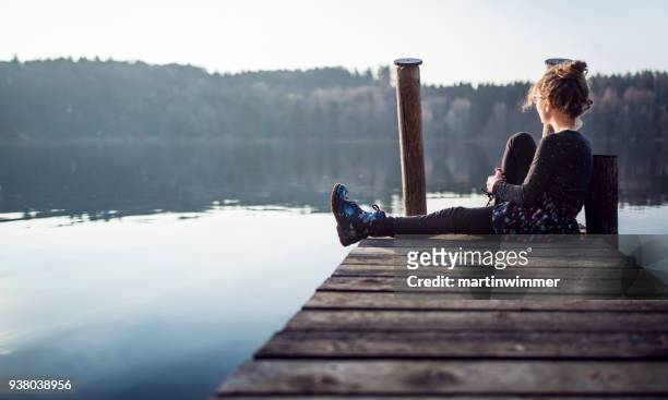jong meisje op een houten pier op een meer in oostenrijk - martinwimmer stockfoto's en -beelden