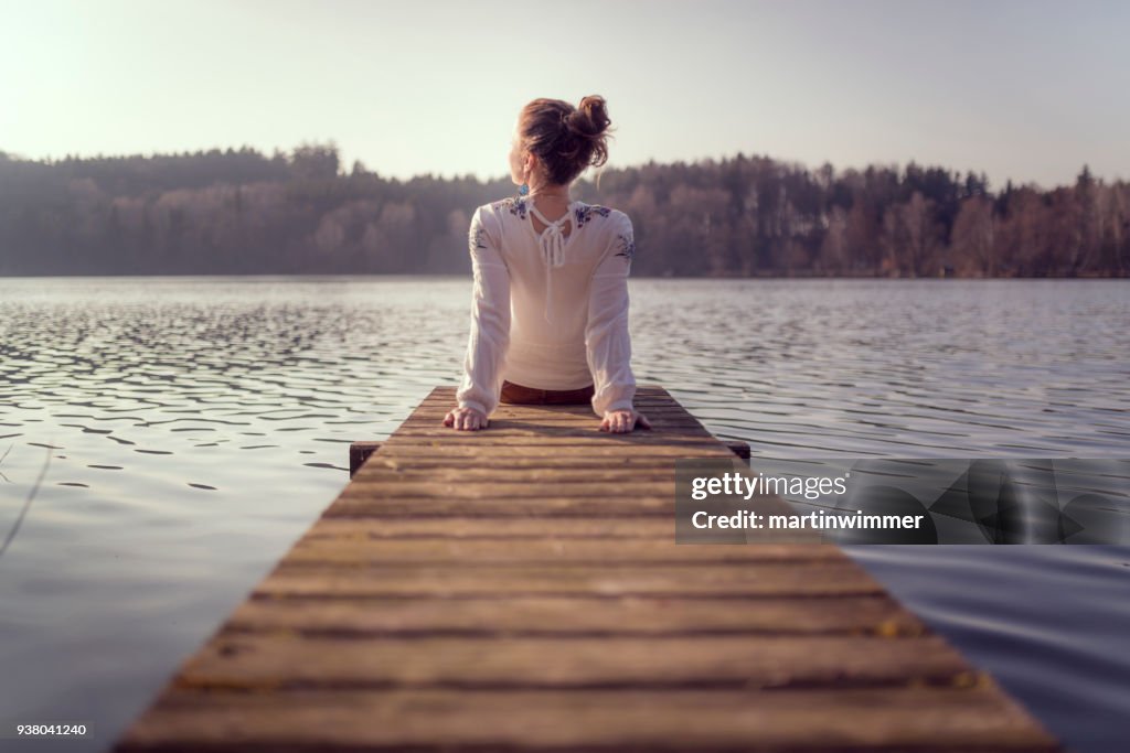 Young women at a wooden pier on a lake in austria