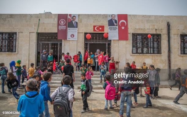 Syrian school children holding Turkish flags, are seen at their school backyard al-Caviz village after Turkish Armed Forces and Free Syrian Army took...