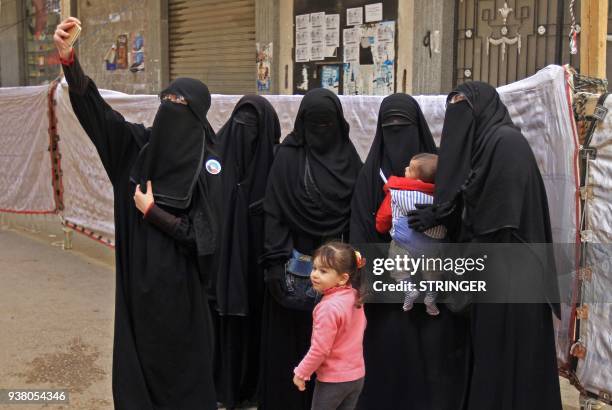 Egyptian women wearing niqab pose for a "selfie" photograph with a cell phone outside a polling station in al-Montazah district of Egypt's second...