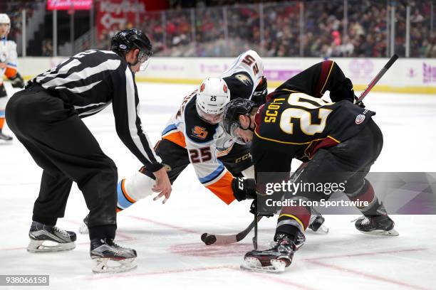 San Diego Gulls center Sam Carrick and Cleveland Monsters center Justin Scott battle for a faceoff during the first period of the American Hockey...