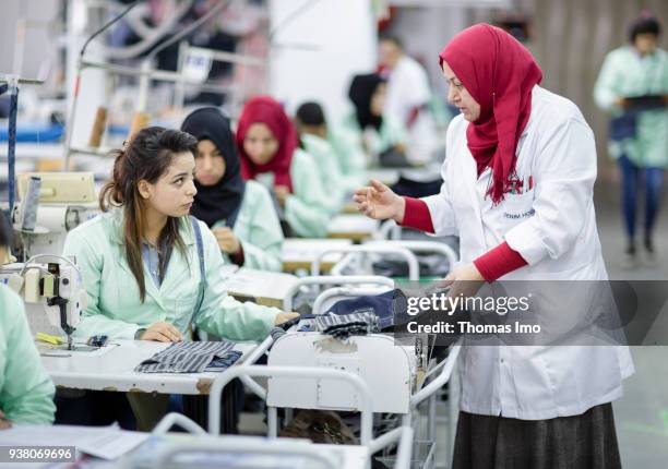 January 01: Training workshop of the textile company Sartex. An employee leads a young seamstress on January 01, 2000 in KSAR HELLAL, TUNISIA.