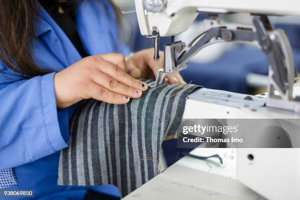 January 01: Production of the textile company Sartex. Close-up of the hands of a young woman while sewing on January 01, 2000 in KSAR HELLAL, TUNISIA.