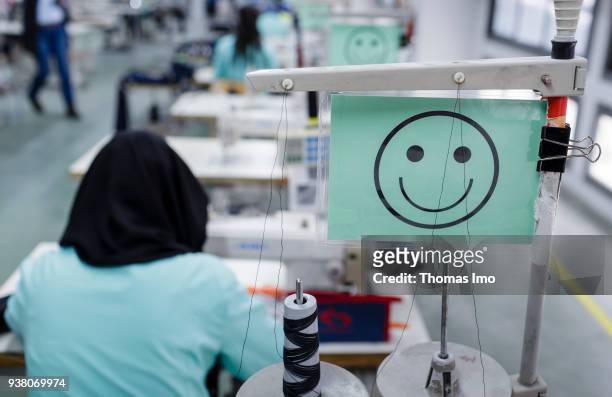 January 01: Production hall of the textile company Sartex. A sign with a laughing smiley hangs at a workplace on January 01, 2000 in KSAR HELLAL,...