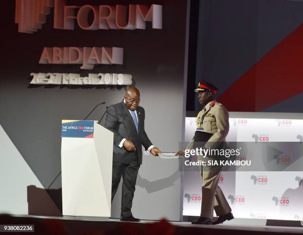 Ghanaian President Nana Akufo-Addo delivers a speech as his aide-de-camp gives him his speech during the opening session of the AFRICA CEO FORUM in...