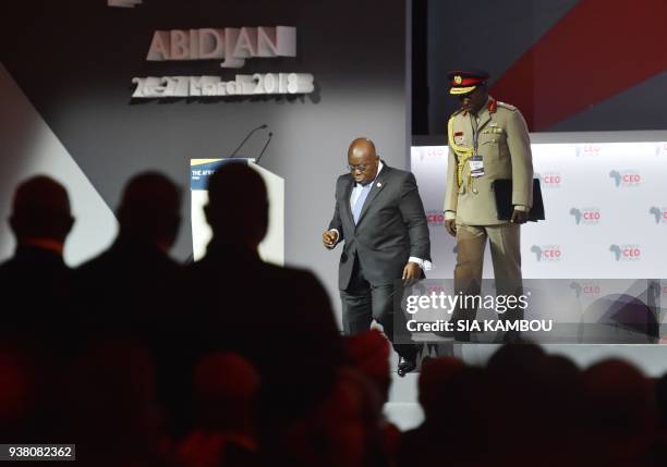 Ghanaian President Nana Akufo-Addo leaves the podium with his aide-de-camp after delivering his speech during the opening session of the AFRICA CEO...