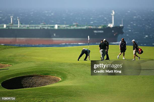 Peter O'Malley marks his ball as Kevin Stadler waits on the 13th green before play was suspended due to prevailing winds during the second round of...