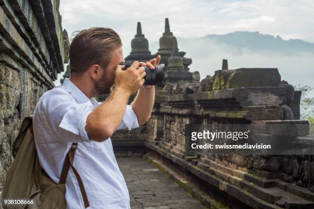 reizen fotograaf man neemt foto's van de borobudur tempel, indonesië - java stockfoto's en -beelden