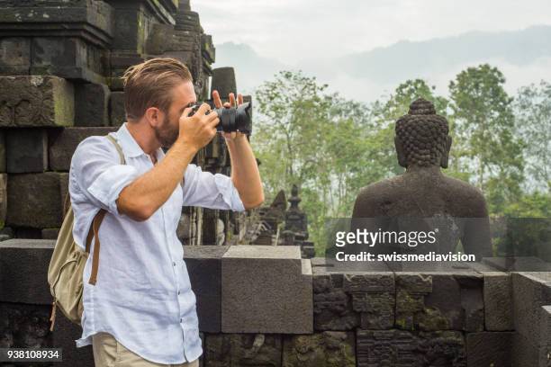 reizen fotograaf man neemt foto's van de borobudur tempel, indonesië - java stockfoto's en -beelden