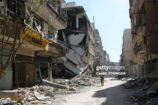 Syrian soldier takes photos in the town of Harasta in Eastern Ghouta on March 26 after government forces entered the town and struck an evacuation...