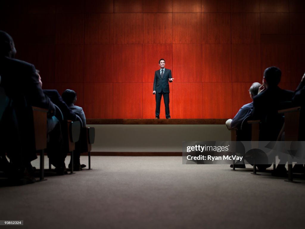 Business man making speech in front of crowd