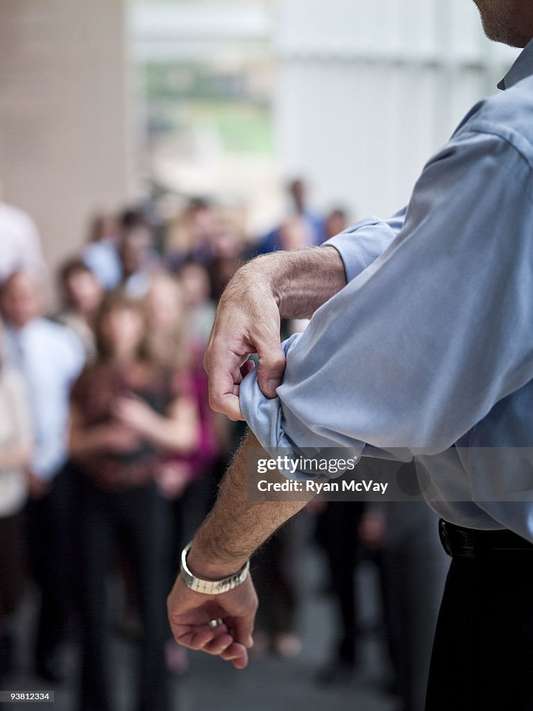 Business man rolling up sleeves