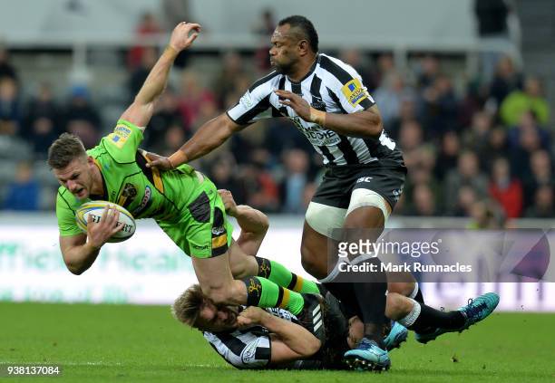 Rob Horne of Northampton Saints is tackled by Chris Harris and Vereniki Goneva of Newcastle Falcons during the Aviva Premiership match between...