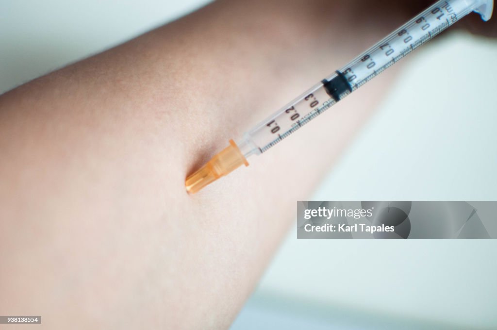 Close up of injecting a medicine on the forearm