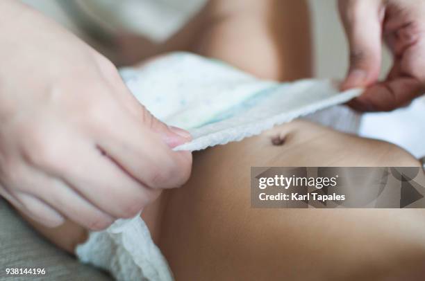 a close up shot of a baby boy changing diaper - changing diaper ストックフォトと画像