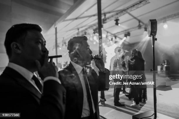 Guests smoking cigars attend the amfAR Hong Kong Gala 2018 at Shaw Studios on March 26, 2018 in Hong Kong, Hong Kong.