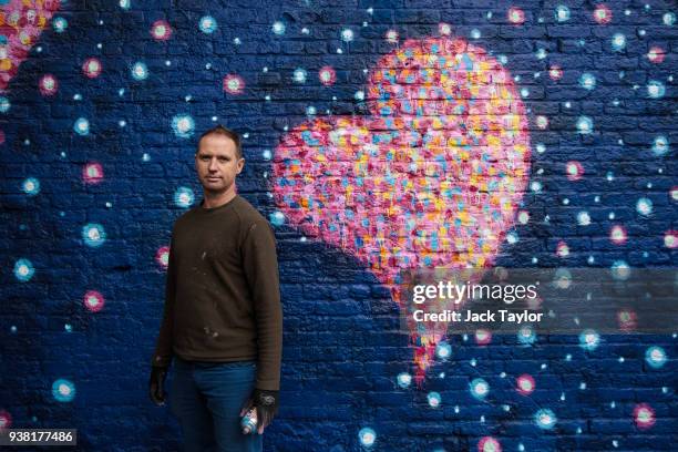 British-born Australian artist James Cochran, known as 'Jimmy C', poses in front of part of his mural to commemorate the victims of the London Bridge...