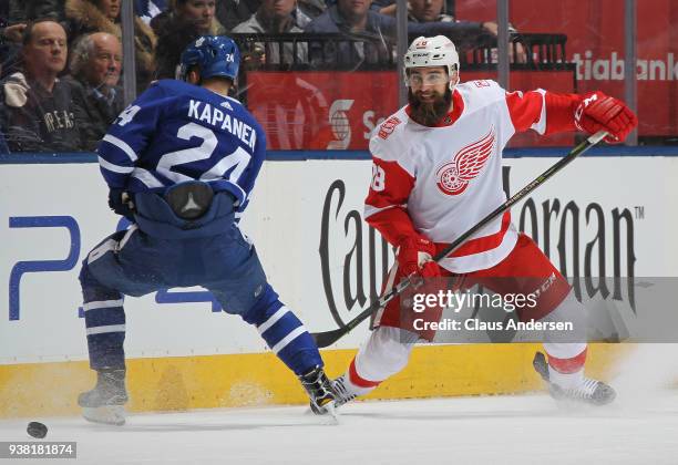 Luke Witkowski of the Detroit Red Wings defends against Kasperi Kapanen of the Toronto Maple Leafs during an NHL game at the Air Canada Centre on...