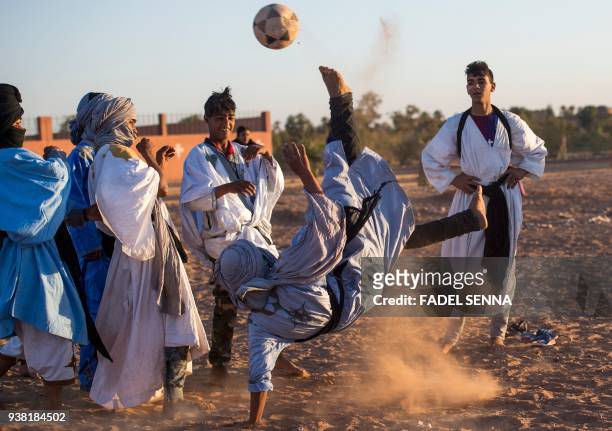 Locals play football during the 15th International Nomad Festival in Mhamid el-Ghizlane in Morocco's southern Sahara desert on March 24, 2018.