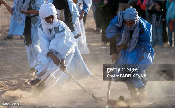 Locals play hockey during the 15th International Nomad Festival in Mhamid el-Ghizlane in Morocco's southern Sahara desert on March 24, 2018.