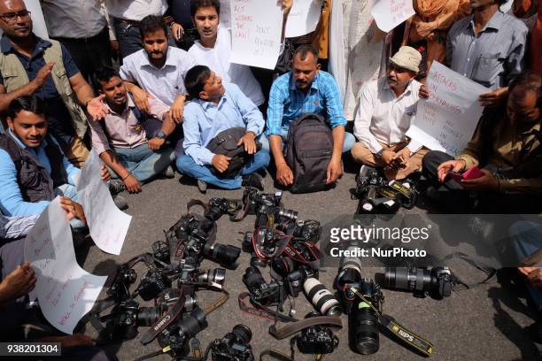 Photojournalists keep down their cameras in protest against Delhi Police's recent assault on media in New Delhi on March 26, 2018. Members of the...