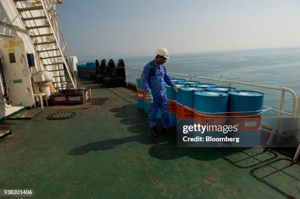 Crew man secures Gulf Marine oil drums on the deck of oil tanker 'Devon' as it prepares to transport crude oil from Kharg Island to India in Bandar...