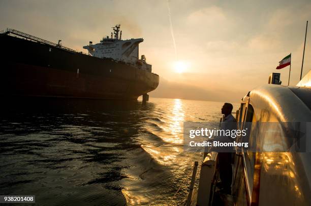 Support vessel flying an Iranian national flag sails alongside the oil tanker 'Devon' as it prepares to transport crude oil to export markets in...