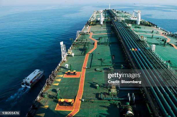 Support vessel sails alongside the crude oil tanker 'Devon' as it sails through the Persian Gulf towards Kharq Island oil terminal to transport crude...