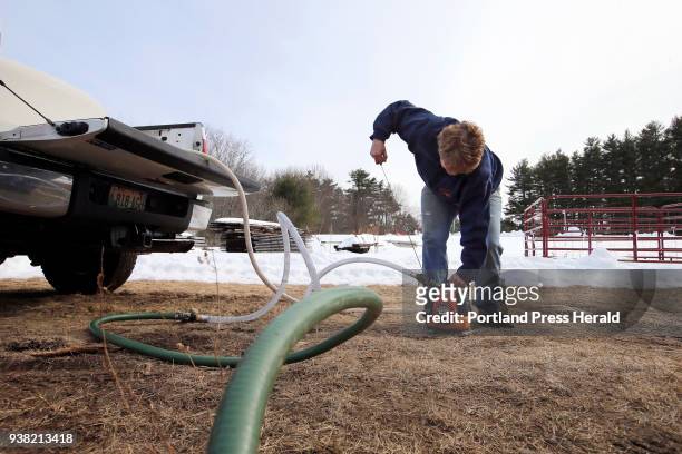 Jo Hartwell, owner of Hartwell Farm, starts a portable gas-powered pump to move sap from a 325-gallon container in the back of her pickup truck into...