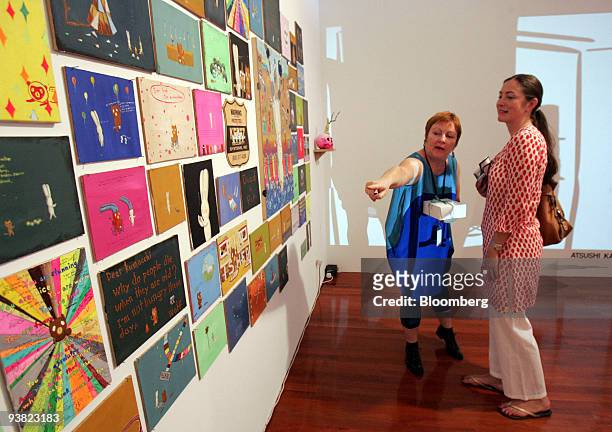 Finola Jones, director of Mother's Tankstation in Dublin, Ireland, left, points out a piece by Atsushi Kaga to Karina Rank, a curator and collector...