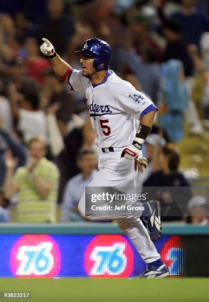 Nomar Garciaparra of the Los Angeles Dodgers celebrates as he rounds first base after hitting a walk off two-run homerun in the tenth inning against...