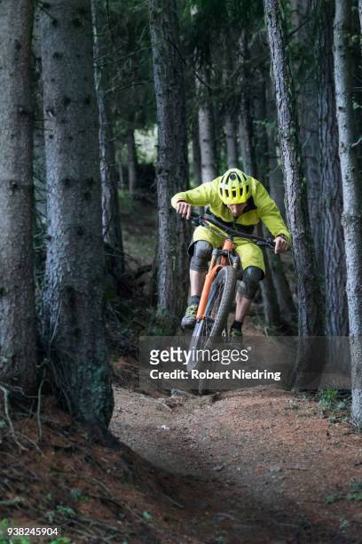 mountain biker jumping with speed on forest path - ganzkörperansicht photos et images de collection