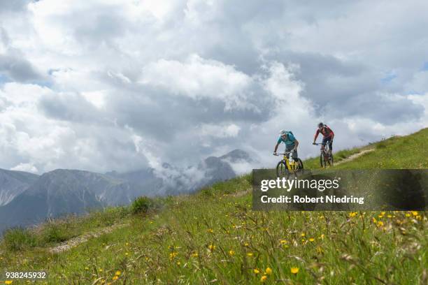 mountain bikers riding down hill, trentino-alto adige, italy - fahrrad fahren stockfoto's en -beelden