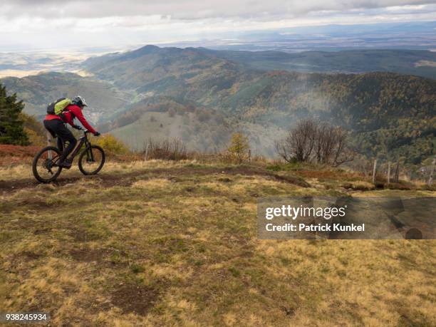 man riding electric mountain bike on cycling tour, vosges, france - geschwindigkeit stockfoto's en -beelden