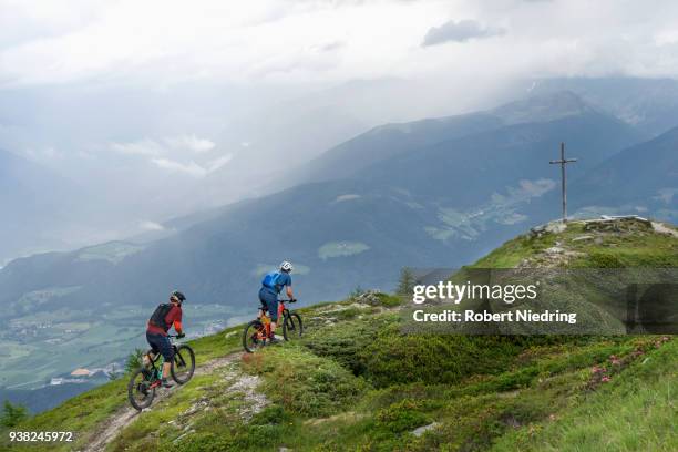 mountain bikers riding uphill, trentino-alto adige, italy - hinauf bewegen fotografías e imágenes de stock