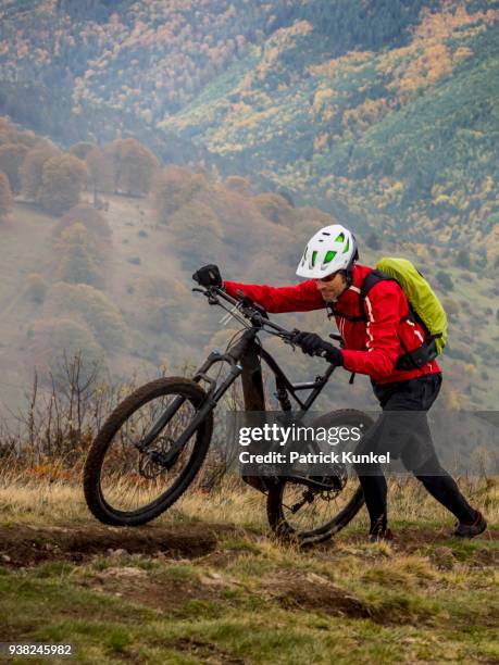 man walking electric mountain bike on cycling tour, vosges, france - ruhige szene 個照片及圖片檔