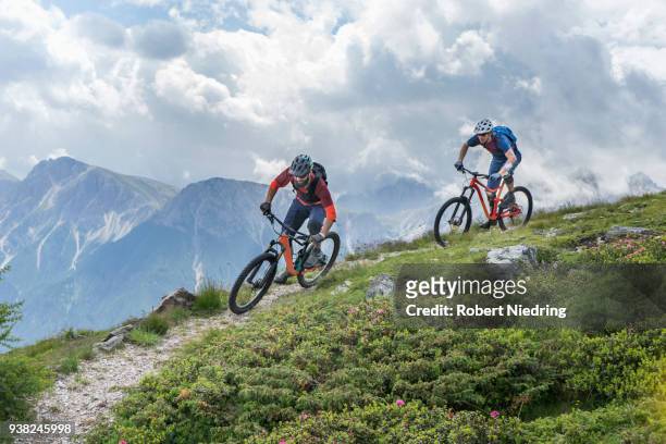 mountain bikers riding on uphill, trentino-alto adige, italy - ganzkörperansicht photos et images de collection