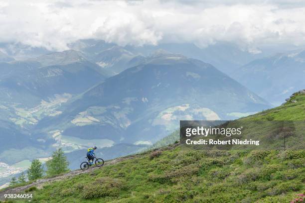mountain biker riding on uphill in alpine landscape, trentino-alto adige, italy - ganzkörperansicht photos et images de collection