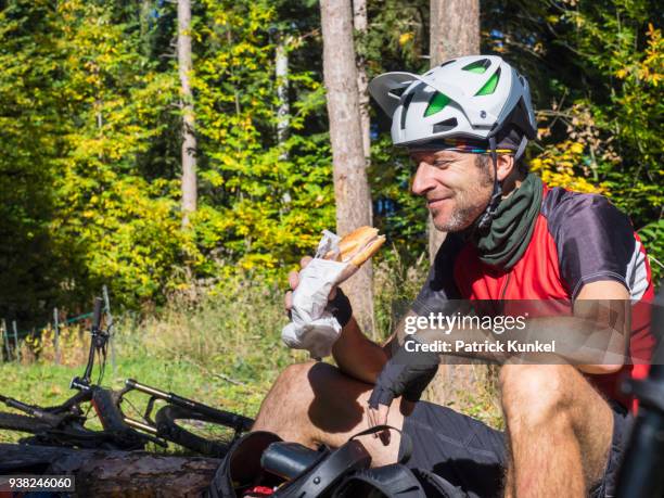 mountain biker taking rest near in woods near the commune of munster, france - draussen stockfoto's en -beelden