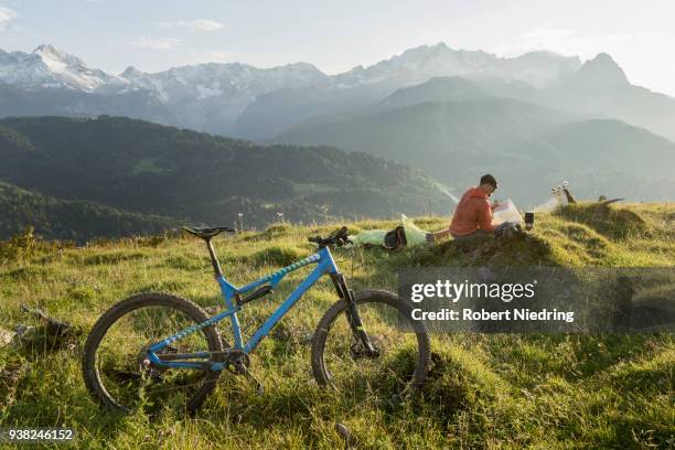 mountain biker relaxing on alpine landscape and looking at map, bavaria, germany - fahrrad fahren stock pictures, royalty-free photos & images