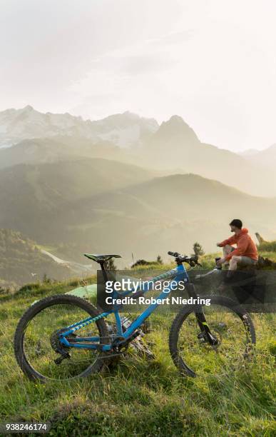 mountain biker taking a break admiring scenic mountain view, bavaria, germany - gipfel bildbanksfoton och bilder