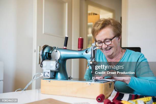 old woman sewing on a machine - lächeln stock pictures, royalty-free photos & images