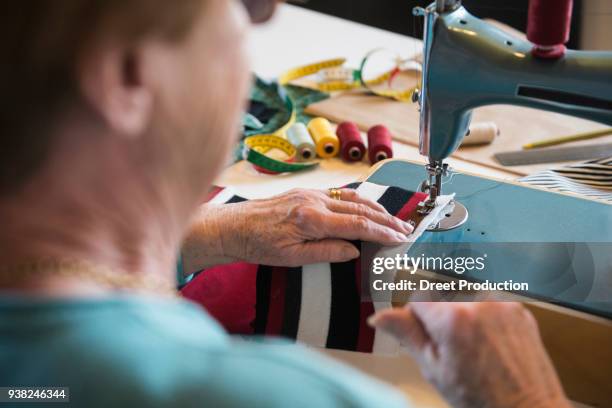 old woman working at sewing machine - das leben zu hause stock pictures, royalty-free photos & images